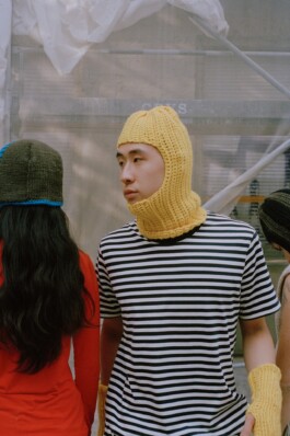 WOOHOO WOOL Image Shoot. Zwei Models stehen vor einem Bauzaun. Sie tragen Strickstyles die mit WOOHOO WOOL hergestellt wurden. Foto: Studio Luzie